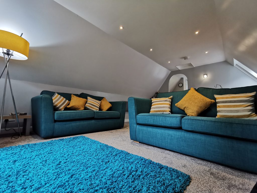 Upper floor seating area with sofas and rug