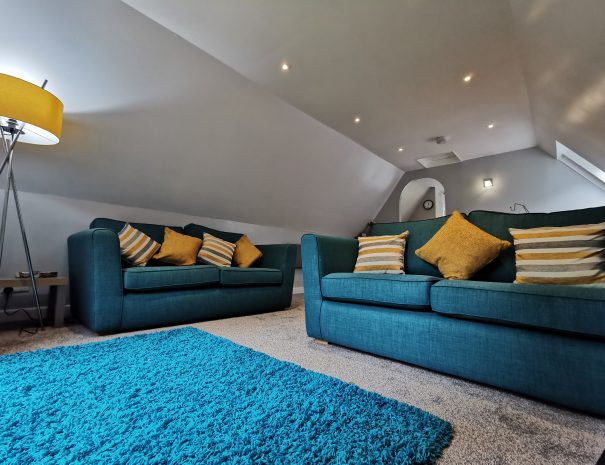 Upper floor seating area with sofas and rug